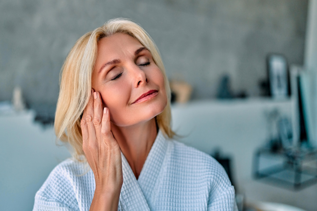 Attractive senior woman with perfect skin doing beauty procedures and anti-aging treatment at home. Morning routine.